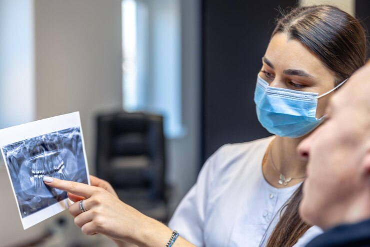 Foto grátis jovem dentista mostrando a um paciente um conceito de radiografia dentária
