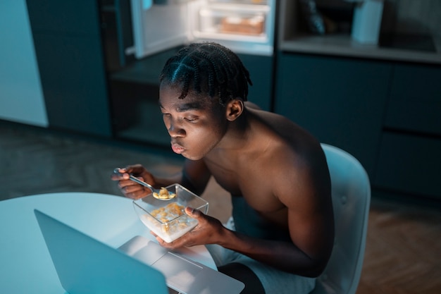 Jovem desfrutando de um lanche em casa no meio da noite