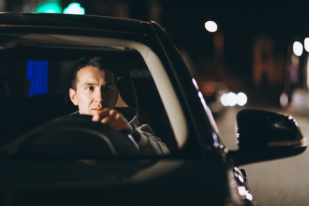 Jovem dirigindo seu carro durante a noite