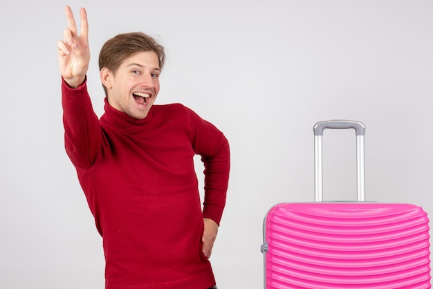 Jovem do sexo masculino com bolsa rosa em fundo branco