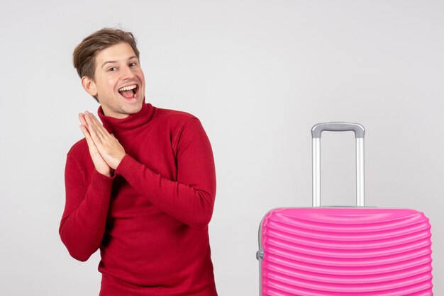 Jovem do sexo masculino com bolsa rosa em fundo branco