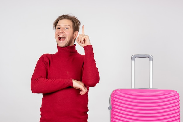 Jovem do sexo masculino com bolsa rosa em fundo branco