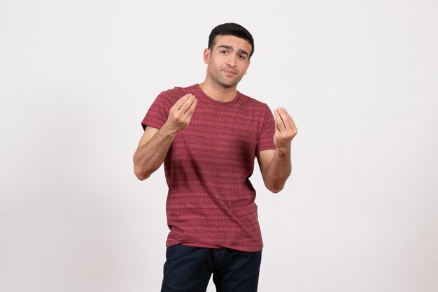 Jovem do sexo masculino de frente para a camiseta, posando em fundo branco