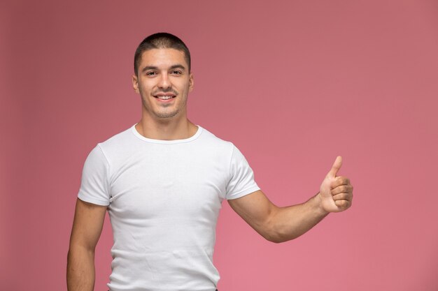Jovem do sexo masculino em uma camiseta branca, sorrindo, mostrando como se estivesse de frente