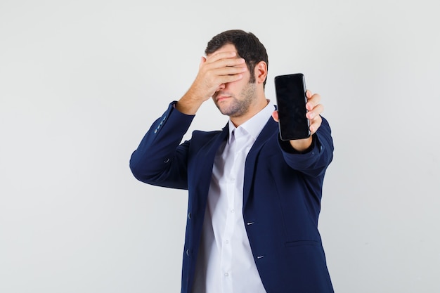 Jovem do sexo masculino segurando um celular na camisa