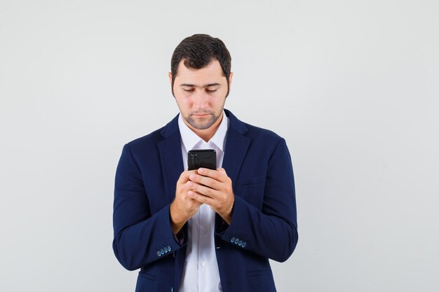 Jovem do sexo masculino usando celular em uma camisa