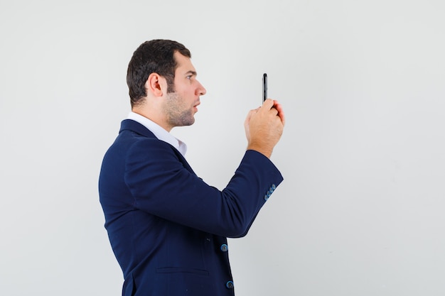 Jovem do sexo masculino usando celular em uma camisa