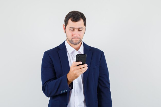 Jovem do sexo masculino usando celular em uma camisa