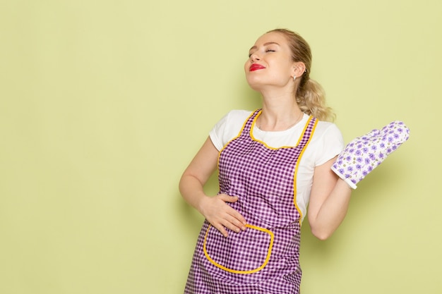 jovem dona de casa com camisa e capa roxa posando em verde