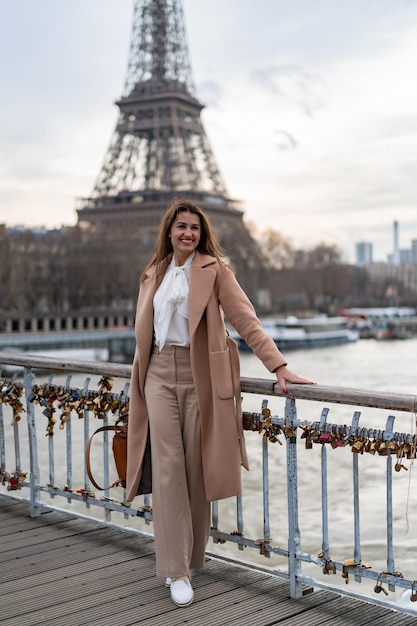 Jovem e bela mulher caminha em paris. o conceito de uma foto de viagem feliz.