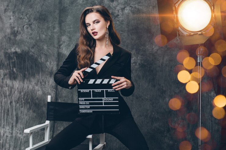 Foto grátis jovem e bela mulher sexy elegante nos bastidores do cinema, segurando um badalo de filme