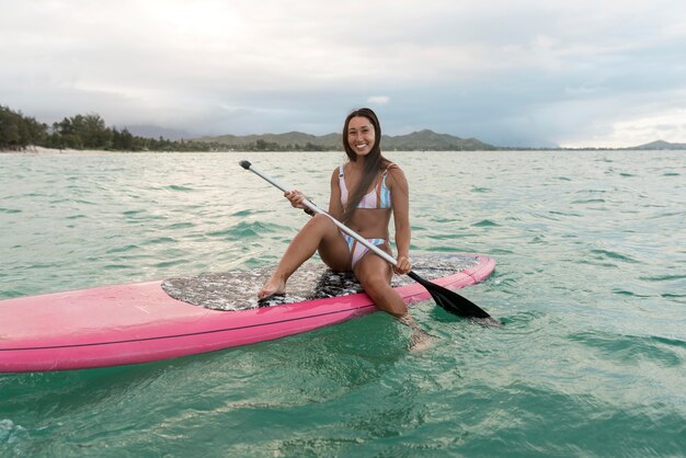 Jovem e bela mulher surfando no Havaí