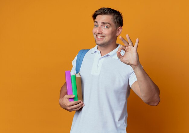 Jovem e bonito estudante sorridente usando uma bolsa com livros