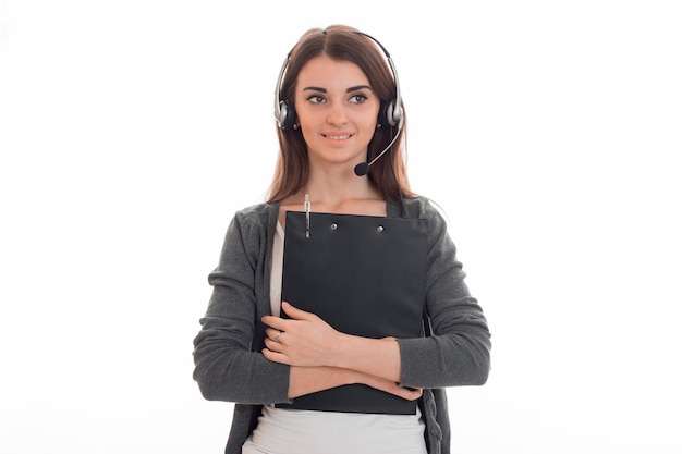 Jovem e charmosa operadora de call center com fones de ouvido isolados na parede branca do estúdio Foto Premium