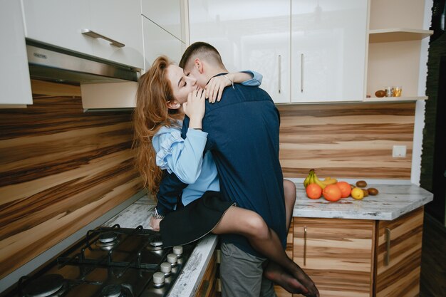 jovem e doce casal adorável dançando na cozinha com frutas