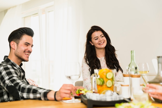 Jovem e homem bonito sentado à mesa