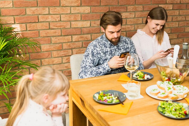 Foto grátis jovem e homem bonito sentado à mesa