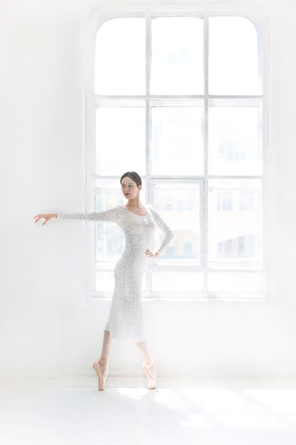 Jovem e incrivelmente linda bailarina está posando e dançando