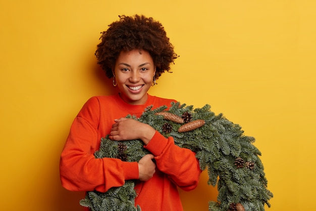 Jovem e linda mulher segurando enfeites de natal