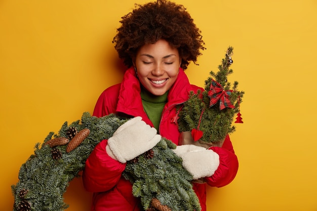 Jovem e linda mulher segurando enfeites de natal