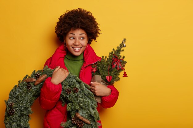 Jovem e linda mulher segurando enfeites de Natal