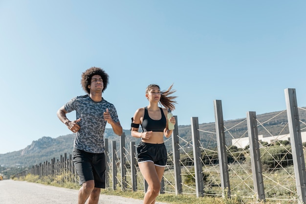 Foto grátis jovem e mulher correndo na estrada