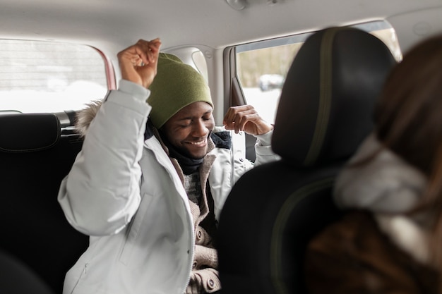 Jovem e mulher no carro, prontos para uma viagem de inverno juntos