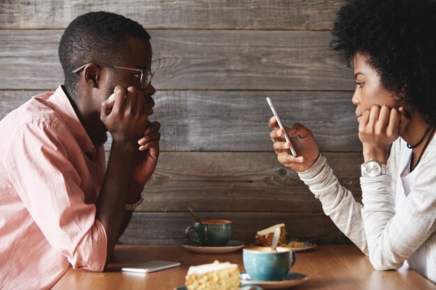 Jovem e mulher sentados em um café