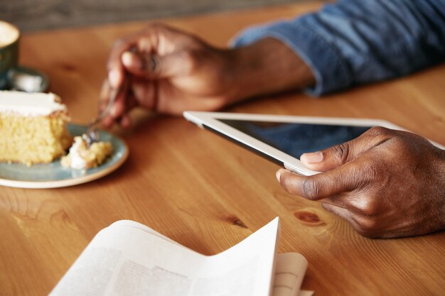 Jovem elegante sentado em um café com um tablet