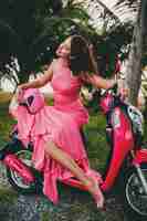 Foto grátis jovem elegante sexy linda mulher com vestido rosa em scooter de moto