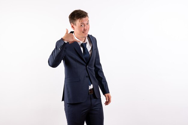 Jovem em elegante terno clássico posando com um sorriso no fundo branco