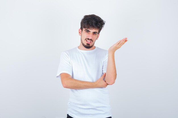 Jovem em pose de questionamento com uma camiseta e parecendo confiante