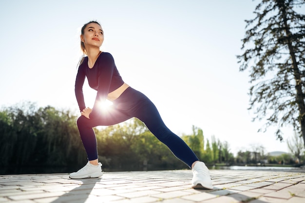 Jovem em traje esporte azul escuro, exercitando-se no parque