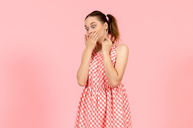 jovem em um lindo vestido brilhante com expressão de choque na cor rosa