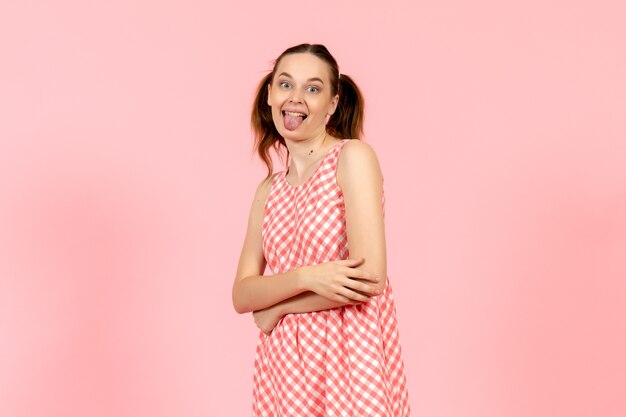 Jovem em um lindo vestido brilhante, mostrando a língua na rosa