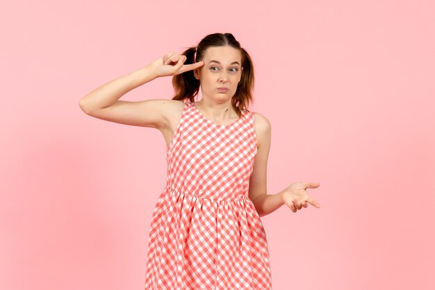 jovem em um lindo vestido rosa com expressão confusa em rosa