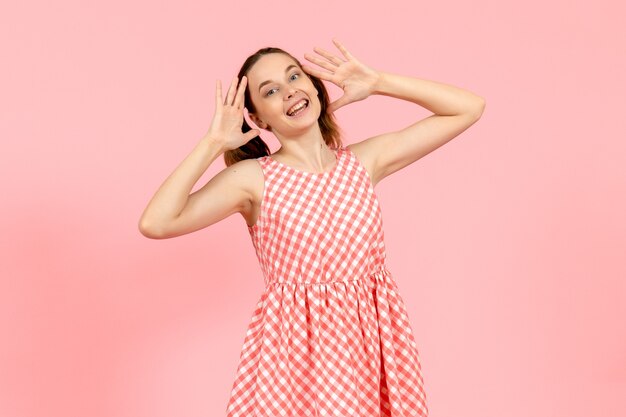 jovem em um lindo vestido rosa com uma cara feliz em rosa