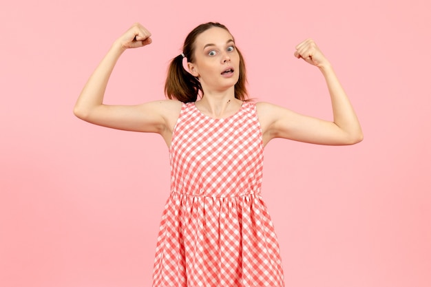 jovem em um lindo vestido rosa flexionando em rosa claro