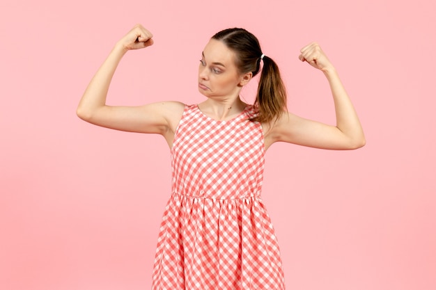 Jovem em um lindo vestido rosa flexionando na rosa