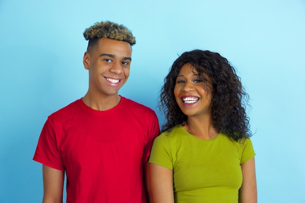 Jovem emocional afro-americano e mulher em fundo azul