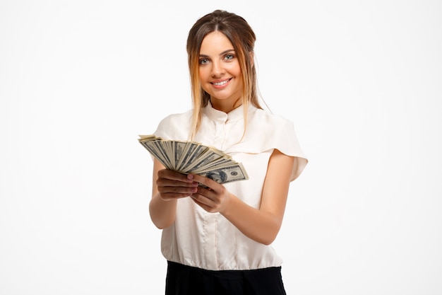 Foto grátis jovem empresária bem-sucedida, segurando o dinheiro sobre fundo branco.