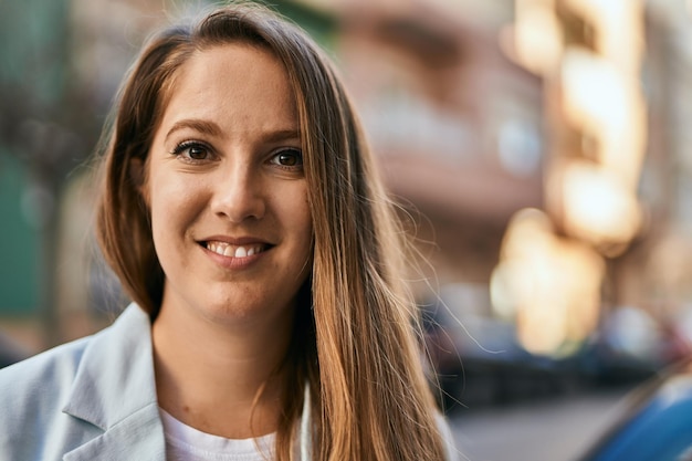 Jovem empresária loira sorrindo feliz em pé na cidade