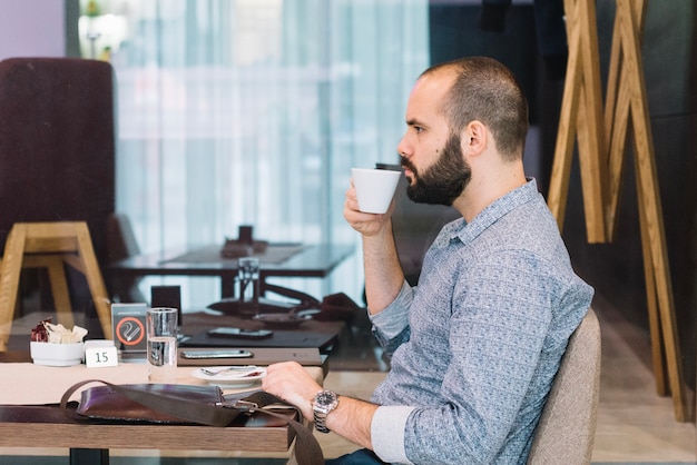 Foto grátis jovem empresário gozando de bebida no café