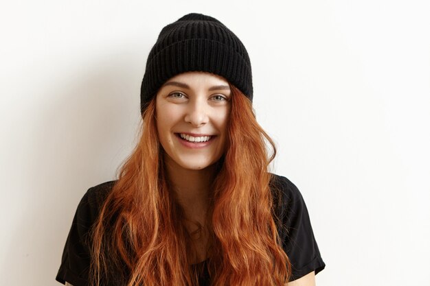 Jovem encantadora com um elegante chapéu preto e uma camiseta com um visual alegre