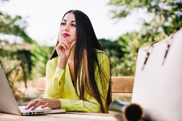 Jovem encantadora que contempla enquanto trabalha