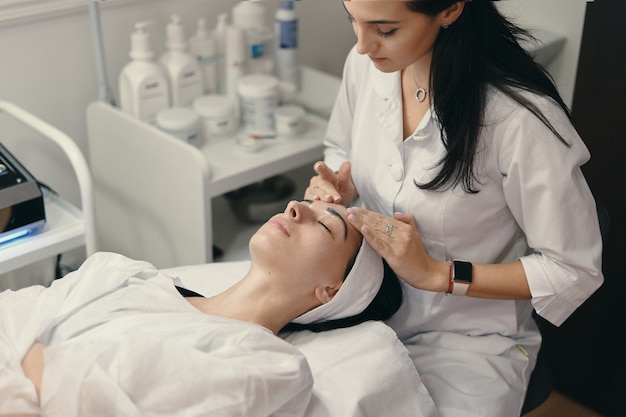 Foto grátis jovem encontra-se com os olhos fechados, procedimento de tomada de cosmetologista