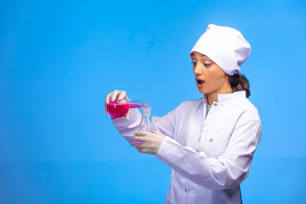 Jovem enfermeira de uniforme branco verifica a reação biológica e fica surpresa