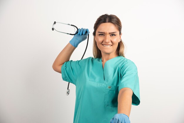 Jovem enfermeira feminina sorridente posando com estetoscópio.