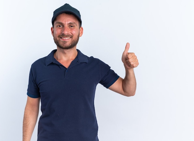 Jovem entregador caucasiano sorridente com uniforme azul e boné aparecendo com o polegar