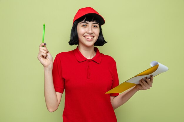 Jovem entregadora caucasiana sorridente segurando uma prancheta e uma caneta